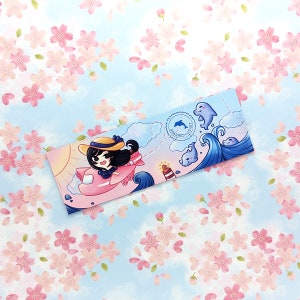 May include: A bookmark featuring a cartoon girl flying a pink airplane with a blue sky and white clouds in the background. The bookmark also has a blue ocean with waves and dolphins. The text "Soaring Hearts" is on the bookmark.