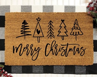 May include: A brown coir doormat with black and white checkered border. The doormat has a black design of five stylized Christmas trees and the text "Merry Christmas".