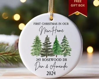 Könnte beinhalten: Weißer Keramik-Weihnachtsbaumschmuck mit einem grünen Aquarell-Baumdesign. Der Anhänger trägt die Aufschrift "First Christmas in our New Home", "345 Rosewood Dr", "Dan & Amanda" und "2024".