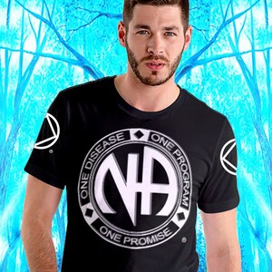 Puede incluir: Camiseta negra con un logotipo circular blanco que dice "One Disease, One Program, One Promise" y tiene las letras "NA" en el centro.