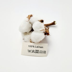 Textile labels made of natural cotton ribbon with the inscription 100% linen