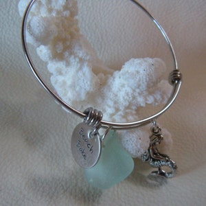 May include: Silver charm bracelet with a mermaid charm, a sea glass charm, and a charm that says "Beach Babe".