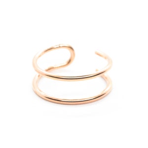 K&ouml;nnte beinhalten: Ein goldener Doppel-Hoop-Ohrring. Der Ohrring besteht aus zwei d&uuml;nnen Reifen, die miteinander verbunden sind.