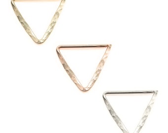 Peut inclure: Trois anneaux de nez en forme de triangle en or, or rose et argent. Chaque anneau a une texture martelée.