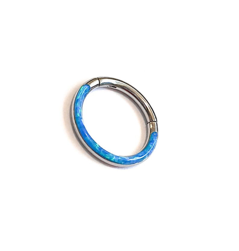May include: A silver seamless ring with a blue opal inlay.
