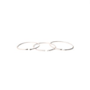 May include: Three silver rings, each with a slightly different diameter, are stacked on top of each other. The rings are simple and minimalist in design.