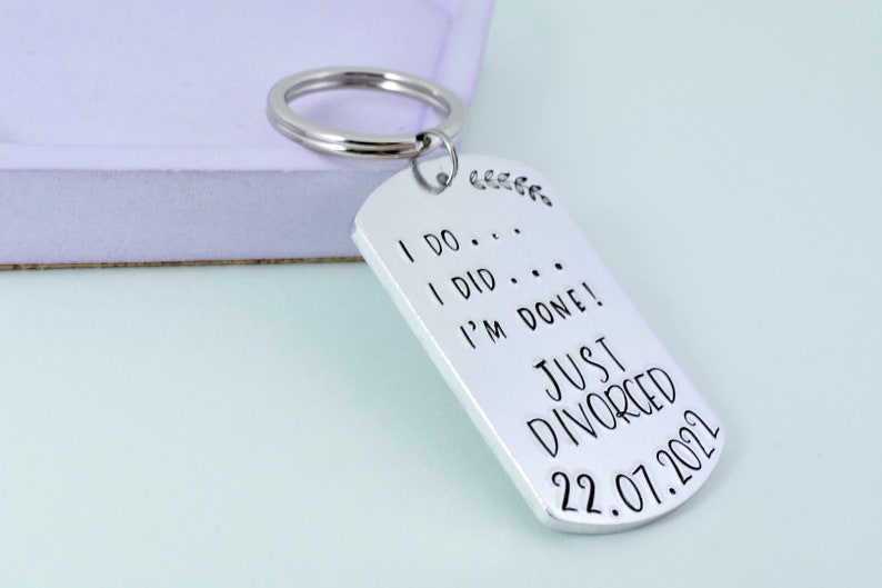 Może przedstawiać: Srebrny brelok do kluczy z wygrawerowanym tekstem "I do... I did... I'm done! Just Divorced 22.07.2021" na kształt wojskowej tabliczki.