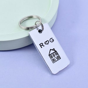 May include: Silver keyring with a house and the initials "R&G" with a heart between the letters.