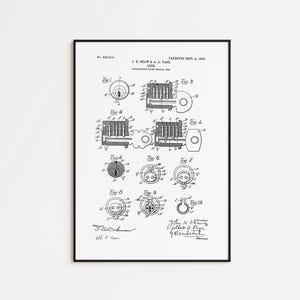 Puede incluir: Impresión enmarcada en negro de una patente de cerradura, con fecha del 4 de septiembre de 1906. La impresión presenta dibujos técnicos detallados de los componentes de la cerradura, con diagramas etiquetados de la Fig. 1 a la Fig. 10. Incluye los nombres J.E. Ream & L.A. Paol.