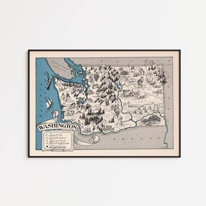 May include: A framed illustrated map of Washington state in blue, black, and cream. The map features drawings of mountains, forests, and animals, with the text WASHINGTON and a list of cities including Seattle, Spokane, Tacoma, Bellingham, and Olympia.
