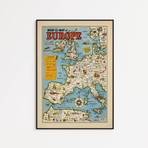 Könnte beinhalten: Eine gerahmte Vintage-Karte von Europa mit dem Titel "MEM-O-MAP of EUROPE" in roter und gelber Schrift. Die Karte zeigt detaillierte Illustrationen von Ländern, Städten und Sehenswürdigkeiten, mit einer Windrose im Mittelmeer. Die Karte ist in einem schwarzen Rahmen.