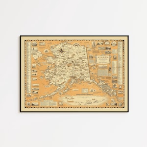 May include: Framed vintage map of Alaska, featuring detailed illustrations and a compass rose. The map is printed on a tan background with a black frame, showcasing the state's geography and historical elements.