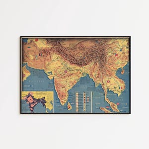 May include: A framed vintage map of Asia, with countries in yellow, brown, and blue. The map includes flags and geographical details, with a smaller inset map. The frame is black.