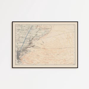 Może przedstawiać: Oprawiona zabytkowa mapa topograficzna z naniesionymi szczegółowymi liniami kartograficznymi, poziomicami i oznaczeniami geograficznymi w odcieniach beżu, czerni i błękitu. Prostokątny wydruk umieszczono w cienkiej czarnej ramie z obramowaniem.