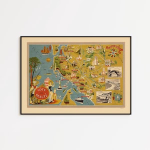 May include: A framed vintage-style pictorial map titled Cote de Beaute, featuring illustrations of coastal landscapes, lighthouses, ships, and local landmarks in shades of yellow, blue, and red, presented in a simple black frame.
