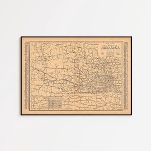 May include: A framed vintage map of Nebraska, featuring a detailed road network. The map is printed on tan paper with black lines and text, and is enclosed in a black frame. The title "Best Roads of Nebraska" is visible.
