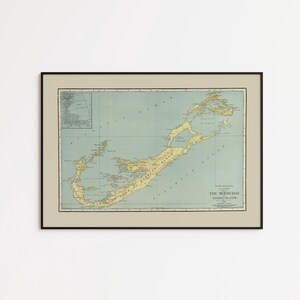 May include: A framed vintage map of Bermuda, showing the islands in yellow and green against a light blue backdrop. The map is in a black frame, offering a classic aesthetic.
