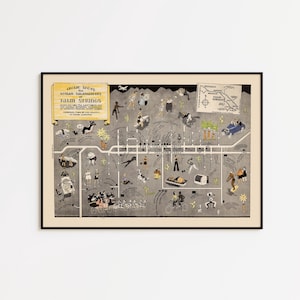 May include: Framed vintage map of Palm Springs, featuring illustrations of people and landmarks. The map has a black frame and includes text that reads "Idle Spots for Human Salamanders Palm Springs".