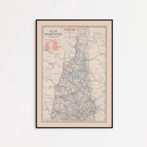 May include: Framed vintage map of New Hampshire, featuring a detailed road network in red and blue against a beige background. The map includes the state name and other text in the upper left corner, encased in a black frame.