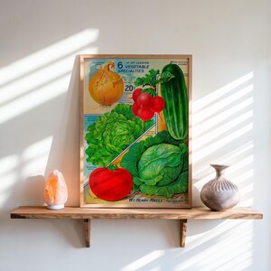 May include: A framed vintage print featuring illustrations of various vegetables, including an onion, radishes, a cucumber, lettuce, a tomato, and cabbage. The print includes the text "6 of My Leading Vegetable Specialties". The print is displayed on a wooden shelf.