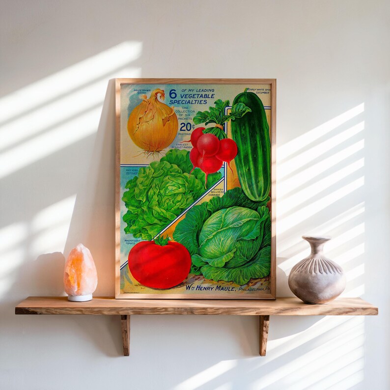 May include: A framed vintage print featuring illustrations of various vegetables, including an onion, radishes, a cucumber, lettuce, a tomato, and cabbage. The print includes the text "6 of My Leading Vegetable Specialties". The print is displayed on a wooden shelf.