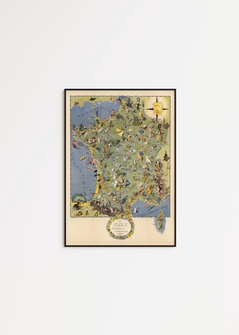 May include: A framed vintage map of France, featuring detailed illustrations of landmarks and cultural elements. The map is in a colorful, illustrative style, with a compass rose and the text "France" at the bottom. The map is framed in a black frame.