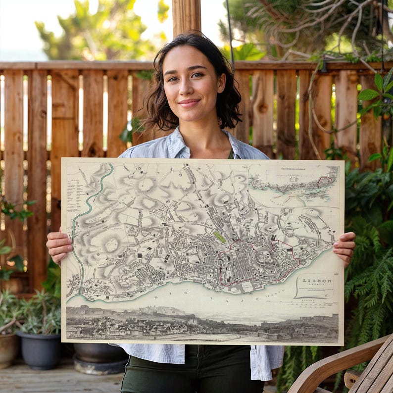 May include: A vintage-style rectangular map of Lisbon printed on cream-coloured paper. The map features detailed black ink illustrations of city streets, topography, and a panoramic view of the harbour at the bottom, with the text LISBON printed.