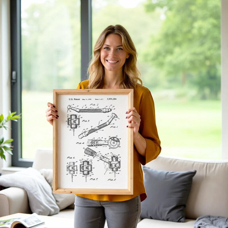 May include: A framed black and white patent print showing diagrams of a dental tool. The print is in a light wooden frame. The text "U.S. Patent" and patent information is visible at the top. The background is a living room setting.