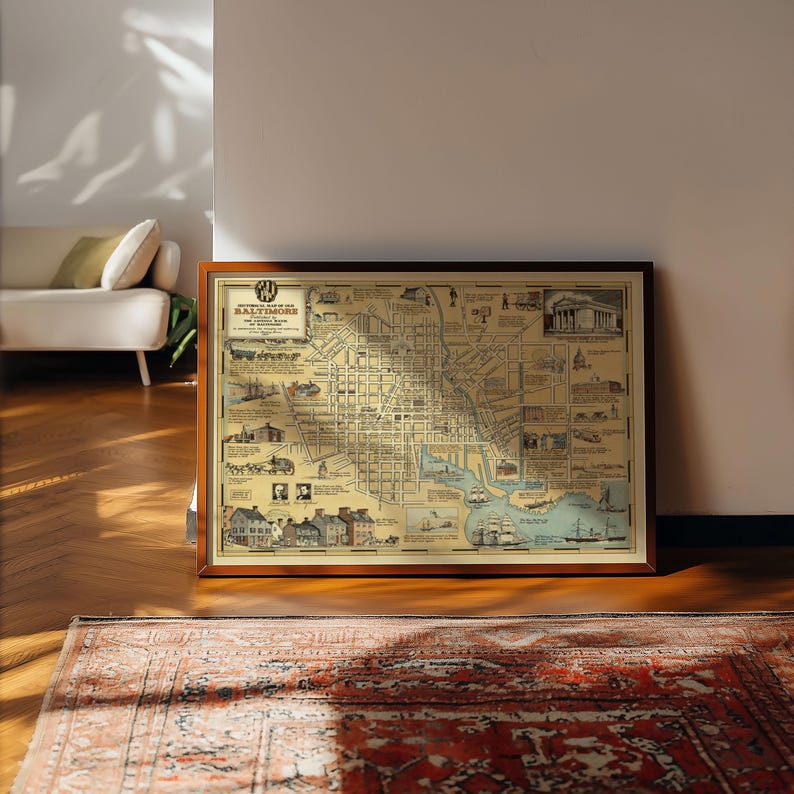 May include: A framed historical map of old Baltimore featuring a cream-colored background with black ink street layouts, illustrations of buildings, ships, and text including the title Historical Map of Old Baltimore, presented in a dark wood frame.