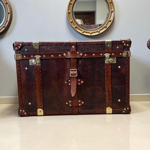 English handmade leather steamer chest in deep brown hand dyed hide with brass hardware and leather buckle straps