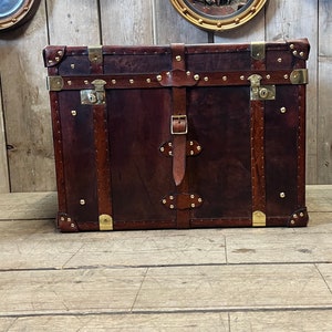 English handmade leather steamer chest in deep brown hand dyed hide with brass hardware and leather buckle straps