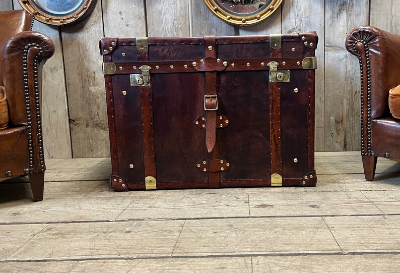 English handmade leather steamer chest in deep brown hand dyed hide with brass hardware and leather buckle straps
