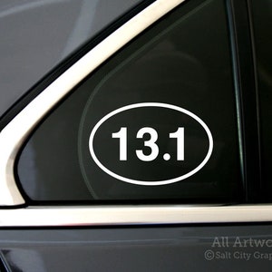 Photo of Salt City Graphics 13.1 Half Marathon decal featuring the number 13.1 inside an oval. The decal is White and shown on the rear corner of a car's passenger window. Photo and artwork copyright Salt City Graphics®.