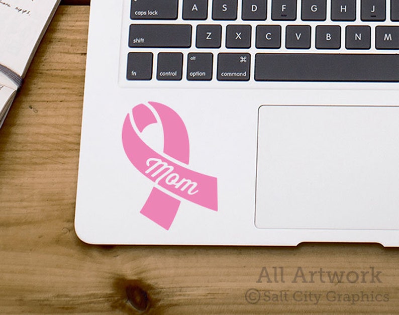 Photo of pink vinyl decal of an awareness ribbon with the word Wife cut out of front shown on laptop