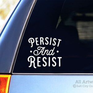 Photo of black vinyl decal of the popular phrase Persist and Resist shown on SUV window
