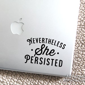 Photo of black vinyl decal of the popular phrase Nevertheless She Persisted shown on laptop