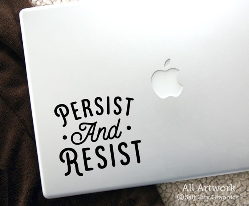 Photo of black vinyl decal of the popular phrase Persist and Resist shown on laptop
