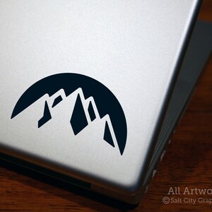 Photo of black vinyl decal of the snowy mountain range shown on laptop