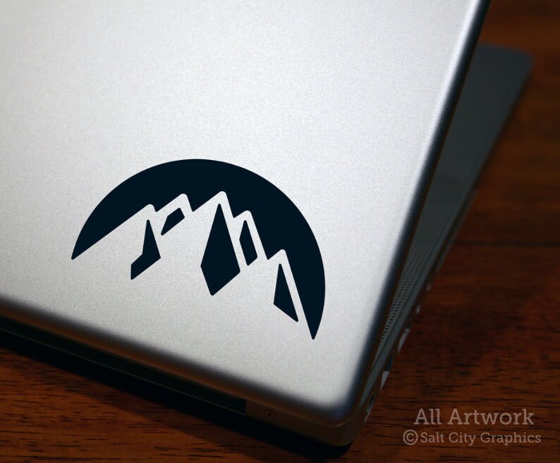 Photo of black vinyl decal of the snowy mountain range shown on laptop