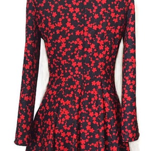 K&ouml;nnte beinhalten: Ein schwarzes und rotes Kleid mit Blumenmuster. Das Kleid hat lange &Auml;rmel und einen taillierten Oberteil. Der Rock ist ausgestellter und reicht bis knapp &uuml;ber das Knie.