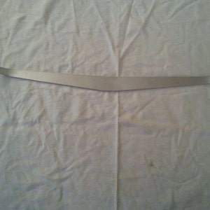 May include: A silver metal curved bar with rounded ends.