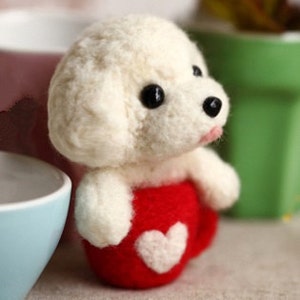 May include: White felt poodle dog figurine sitting in a red felt mug with a white heart on the front.