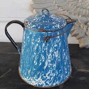 May include: Blue and white speckled enamel teapot with a black handle and a wire lid holder.
