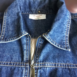 May include: A blue denim jacket with a zip fastening and a label that reads "Harry Potter" made in China.