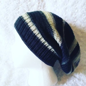 May include: A black and white striped slouchy beanie hat. The hat is crocheted and has a slouchy fit.