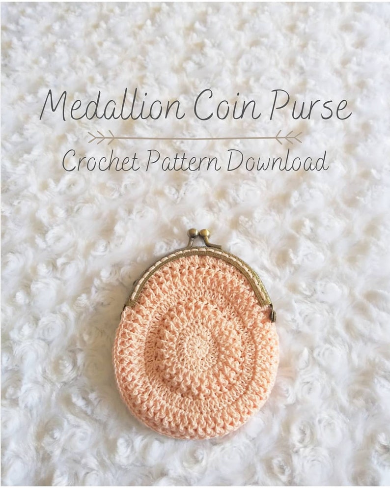 Peut inclure: Une bourse &agrave; monnaie en crochet avec un motif de m&eacute;daillon de couleur p&ecirc;che. La bourse a un fermoir en laiton et est pos&eacute;e sur une surface blanche et moelleuse. Le texte "Medallion Coin Purse Crochet Pattern Download" est au-dessus de la bourse.