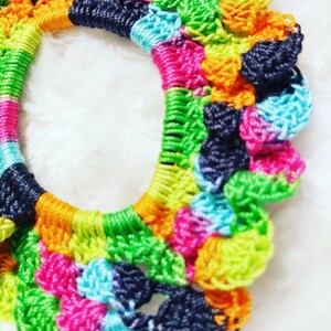 Peut inclure: Un &eacute;lastique &agrave; cheveux en crochet color&eacute; avec un arc-en-ciel de couleurs, notamment le vert, le bleu, le rose, l'orange et le noir.