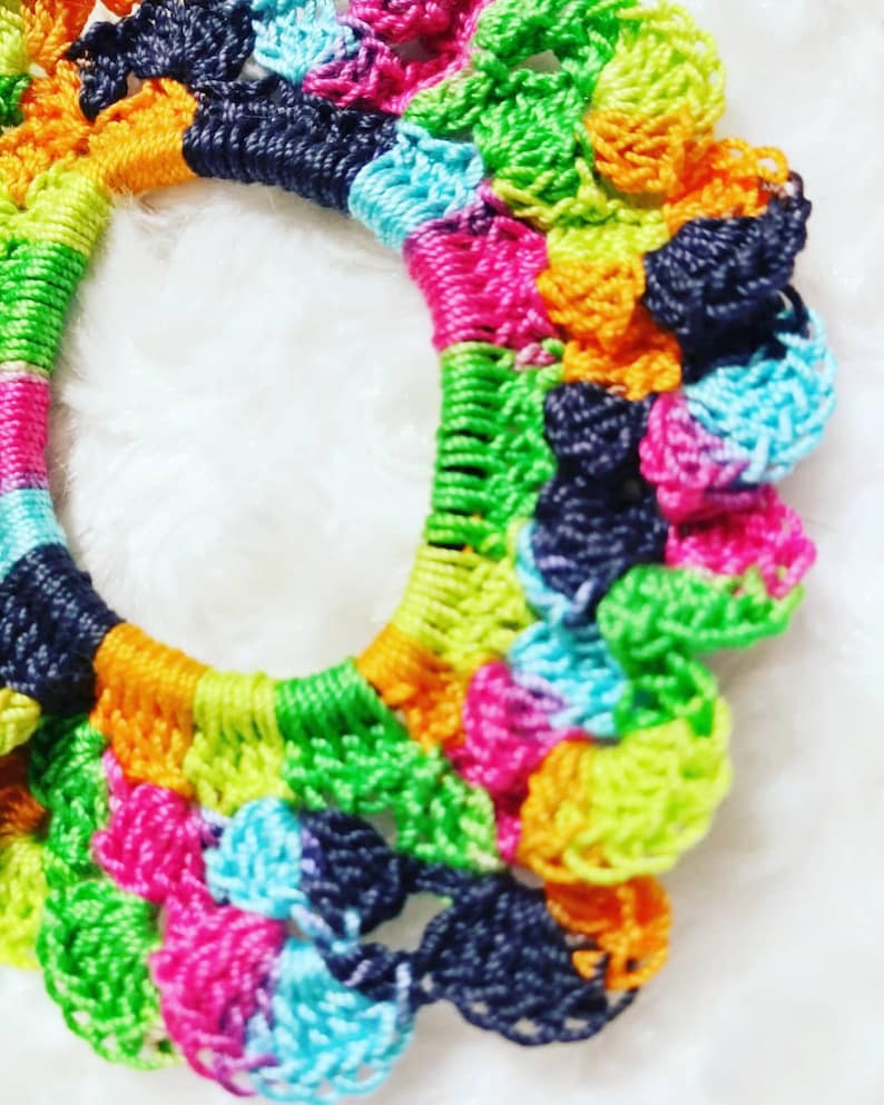 Peut inclure: Un &eacute;lastique &agrave; cheveux en crochet color&eacute; avec un arc-en-ciel de couleurs, notamment le vert, le bleu, le rose, l'orange et le noir.