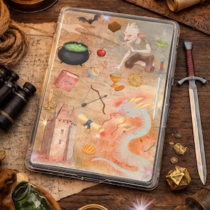 May include: A fantasy-themed tablet case with a dragon, castle, and magical items. A sword, compass, and other accessories surround the case on a wooden surface. The artwork includes a cauldron, bow and arrow, and a scroll. The case is approximately 20 cm x 13 cm.