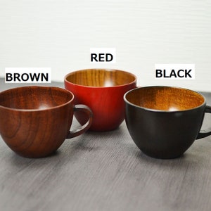 May include: Three wooden cups with handles. The cups are in brown, red, and black. The inside of each cup is made of natural wood.